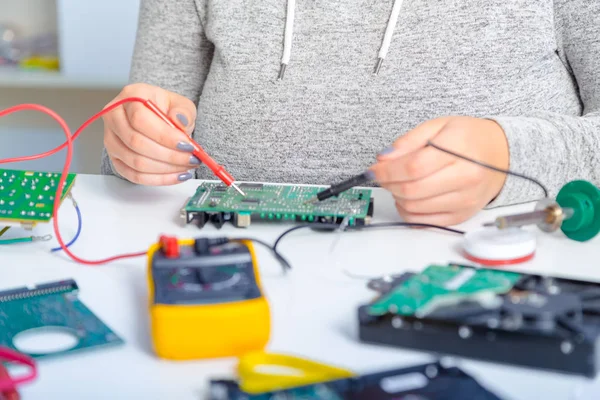 Schoolgirl  repairing the electronic printed circuit board.Computer repair