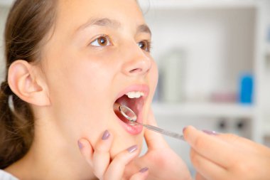 Küçük kızın ağzını tedavi sırasında geniş açılış yakın çekim..