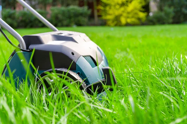 Vertikutierer auf grünem Rasen. Arbeit im Garten. — Stockfoto