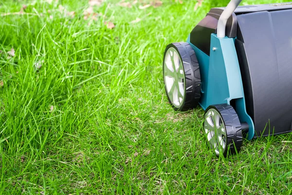 Verticuteermachine op groen gras. Werken in de tuin. — Stockfoto