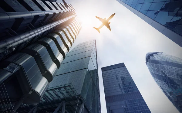 Avião sobre várias torres de escritório — Fotografia de Stock