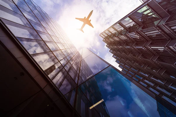 Avião sobre edifícios altos — Fotografia de Stock