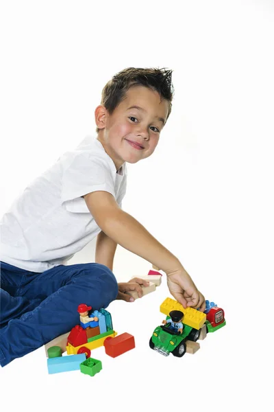 Красивый пятилетний мальчик играет на полу — стоковое фото