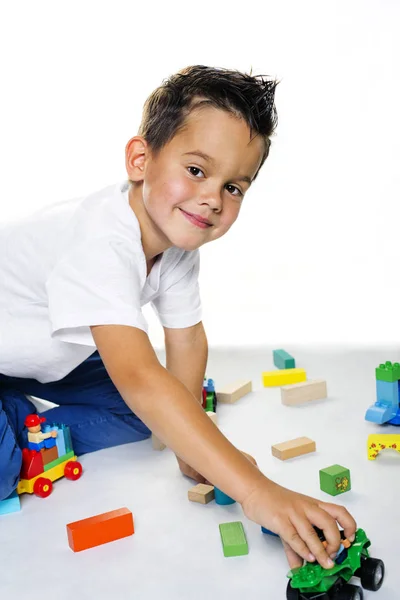 Stilig fem-årig pojke som leker på golvet — Stockfoto
