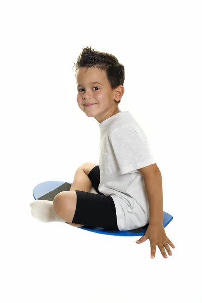 Five year old boy sitting on a balance board — Stock Photo, Image