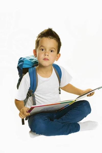 Junge liest auf dem Boden sitzend ein Buch — Stockfoto