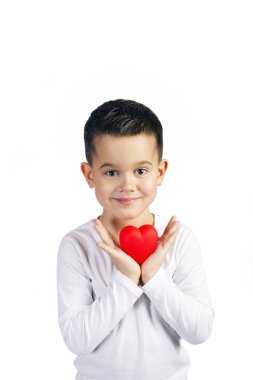 Bir kırmızı kalp heykelcik tutan beş yaşında boy gülümseyerek