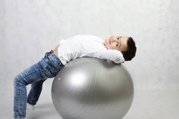 Boy doing exercises with gymnastic equipment — Stock Photo, Image
