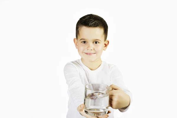 Chlapec pije vodu ze skla pohár — Stock fotografie