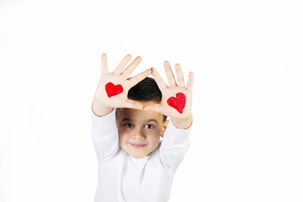 Мальчик с поднятыми руками, раскрашенный сердцами — стоковое фото