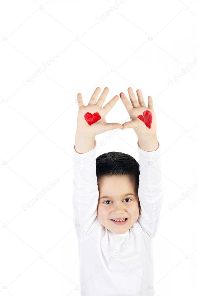 Boy with raised hands painted with hearts