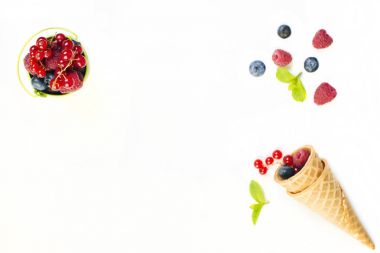 Yaz çilek, ahududu ve gözleme koni Beyaz ahşap zemin üzerinde yaban mersini