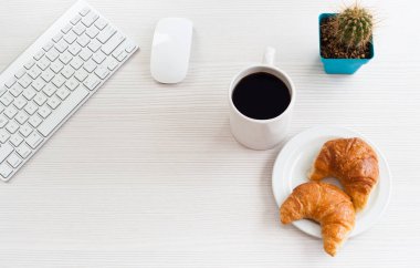 Üstten Görünüm Ofis Masası. Anahtar sözcük, kahve ve kruvasan beyaz masada.