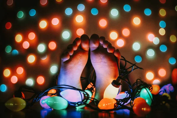 Human feet and colorful garland — Stock Photo, Image