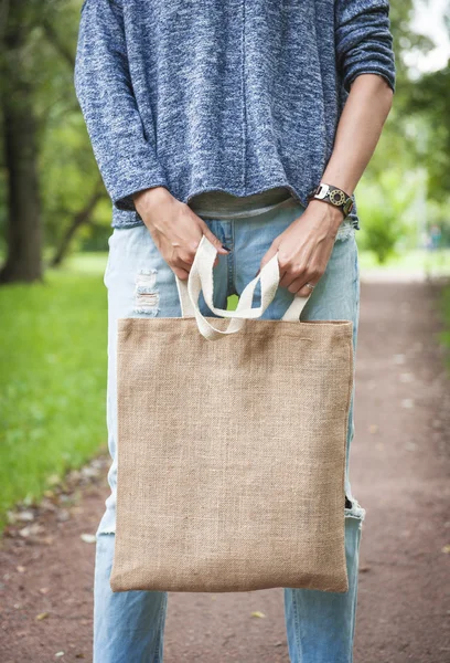 Mujer sosteniendo bolsa de lona vacía. Plantilla maqueta arriba — Foto de Stock