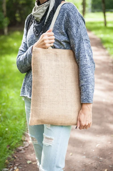 Mujer sosteniendo bolsa de lona vacía. Plantilla maqueta arriba —  Fotos de Stock