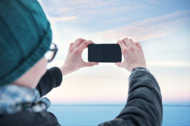 Kadın alarak resim üstünde hareket eden telefon kışın