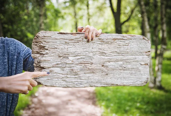 Das leere Holzbrett wird von der Hand einer Frau gehalten. Vorlage gefälscht — Stockfoto