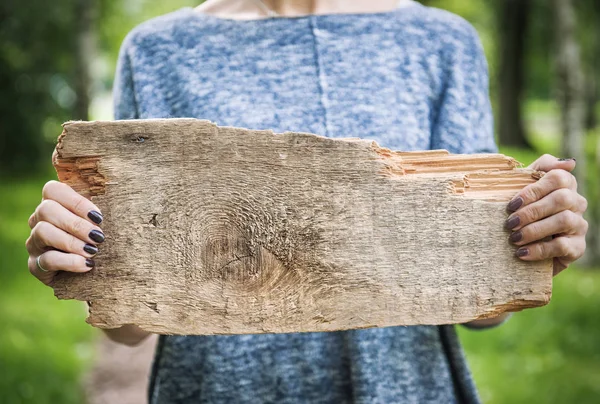 Leere Holzbretter, die von Frauenhänden gehalten werden. Vorlage gefälscht — Stockfoto