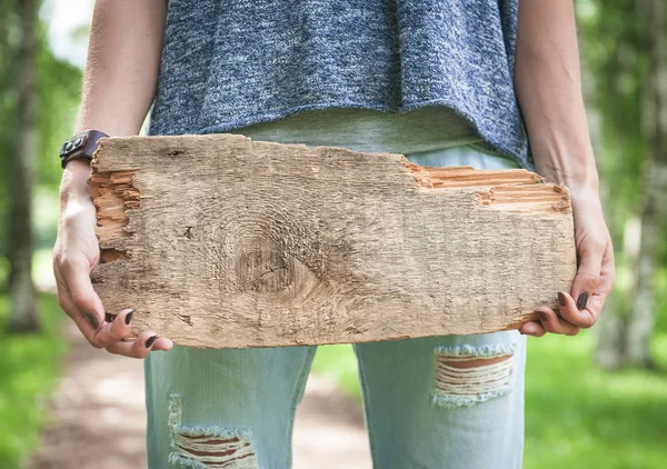 Das leere Holzbrett wird von der Hand einer Frau gehalten. Vorlage gefälscht — Stockfoto
