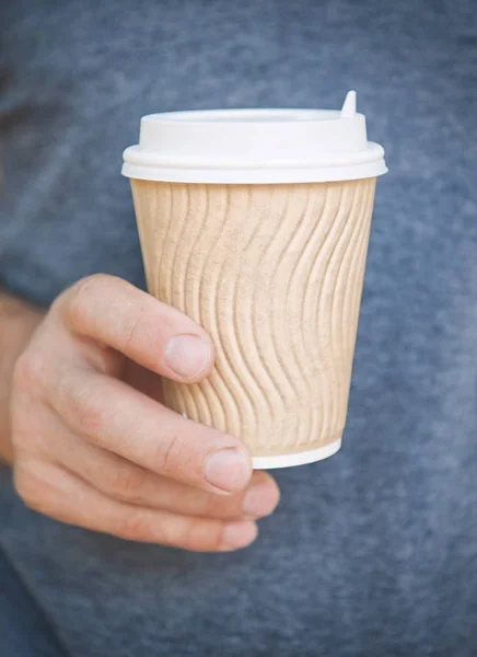 Un homme tenant une tasse de café vide. Modèle de maquette — Photo