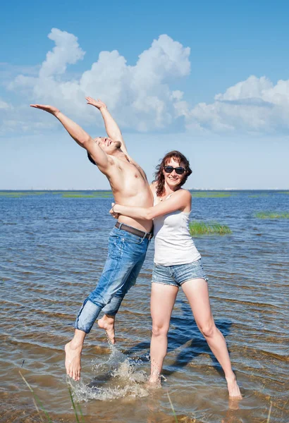 Feliz joven pareja divirtiéndose en el agua del mar —  Fotos de Stock