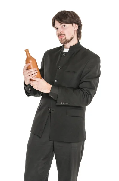 Joven sacerdote con botella de alcohol aislado — Foto de Stock