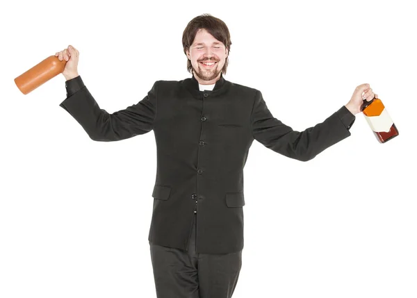 Young cheerful priest with bottle of alcohol isolated — Stock Photo, Image