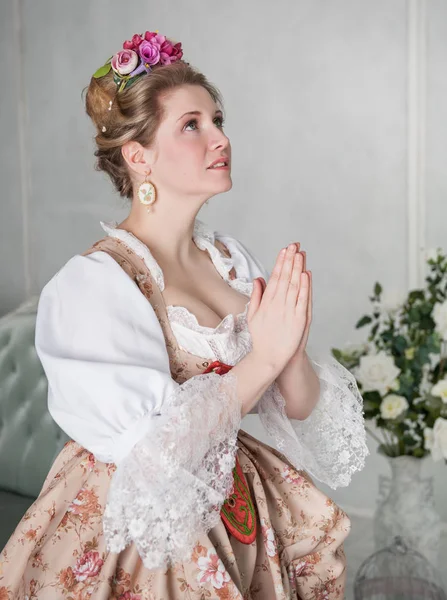 Beautiful medieval woman in dress praying — Stock Photo, Image