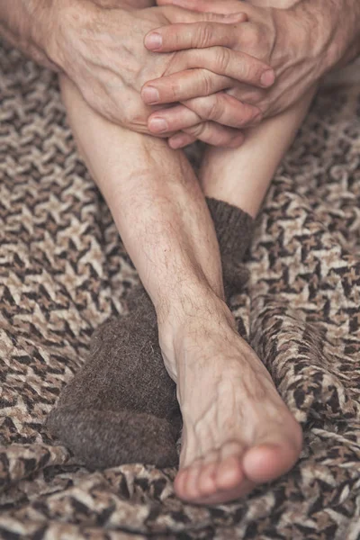 Man feet on woolen plaid in one woolen sock — Stock Photo, Image