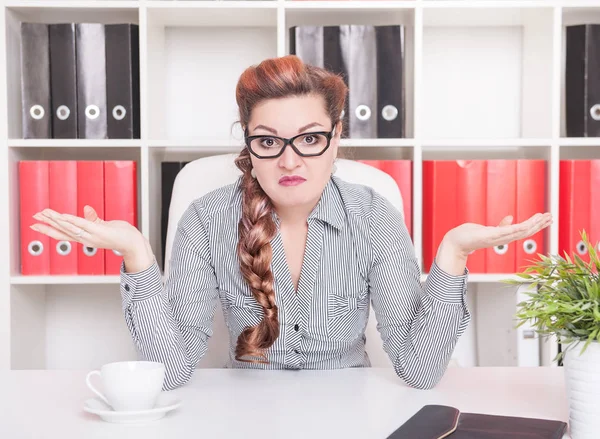 Business woman shrugging her shoulders in office — Stock Photo, Image