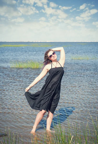 Glückliche junge schöne Frau, die im Meer steht — Stockfoto