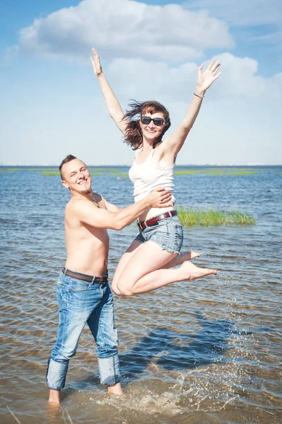 Feliz joven pareja divirtiéndose en el agua del mar —  Fotos de Stock