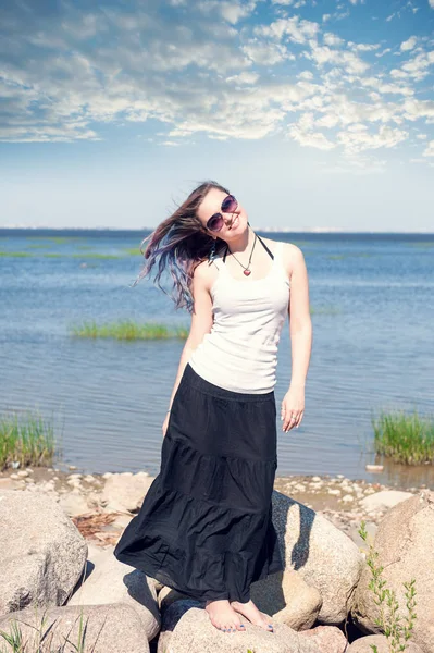 Happy young beautiful woman standing near the sea — Stock Photo, Image