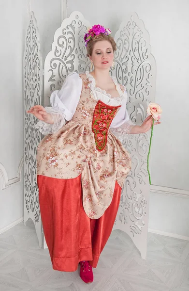 Όμορφη γυναίκα σε μεσαιωνικό φόρεμα κρατώντας ροζ τριαντάφυλλο — Φωτογραφία Αρχείου