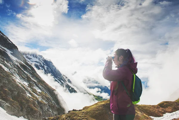 Escursionista donna in piedi sulla cima della montagna e guardando in binoc — Foto Stock