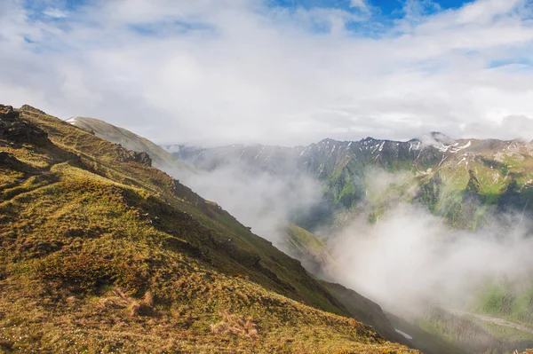 Красивый горный пейзаж в тумане и голубом небе — Бесплатное стоковое фото