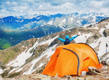 Turist çadır kampında dağ manzarası arasında mutlu bir adam ile 