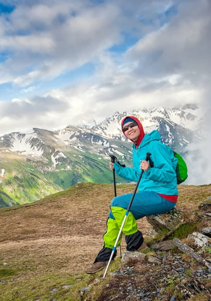 Gelukkig jongedame wandelaar zitten op de top van berg — Stockfoto