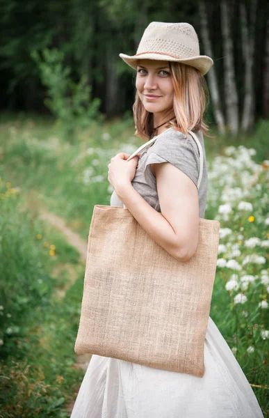 Mujer sosteniendo bolsa de lino vacía. Plantilla maqueta arriba — Foto de Stock