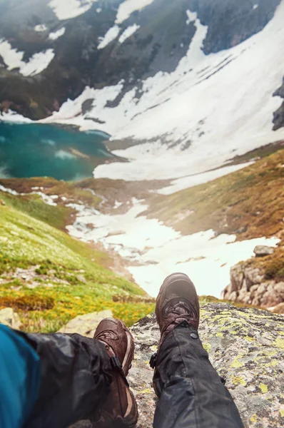 山の頂上に座っている旅行者の足。旅行の概念 — ストック写真