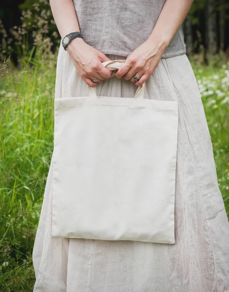 Woman holding empty linen bag. Template mock up