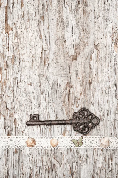 Fundo vintage com chave velha e pano de renda em madeira — Fotografia de Stock