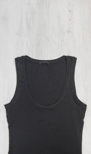 Black tank top on wooden background. Mock-up design template