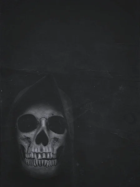 Human skull in hood on dark background. Halloween banner — Stock Photo, Image