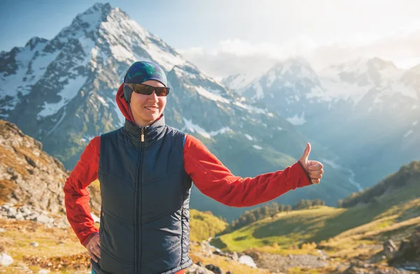 Mujer feliz excursionista en la cima de la montaña y mostrando los pulgares hacia arriba — Foto de Stock