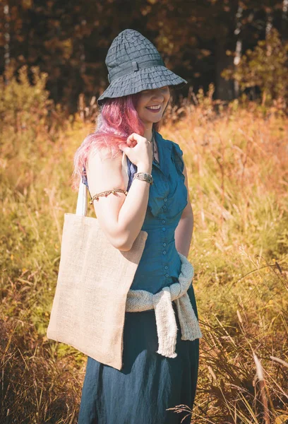 Happy woman holding linen bag in summer field. Template mock up — Stock Photo, Image