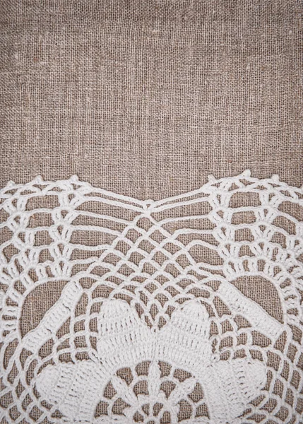 Vintage lace fabric border on the old burlap textile — Stock Photo, Image