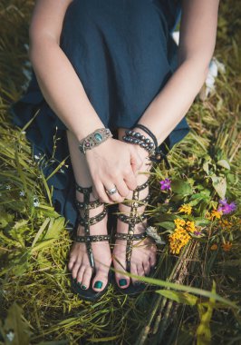 Yaz çayır çimlerde oturan kadın bacakları 