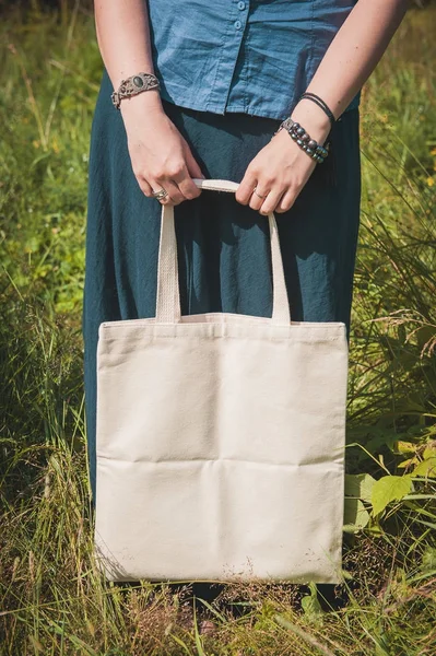 Mujer sosteniendo bolsa de lino vacía. Plantilla maqueta arriba — Foto de Stock
